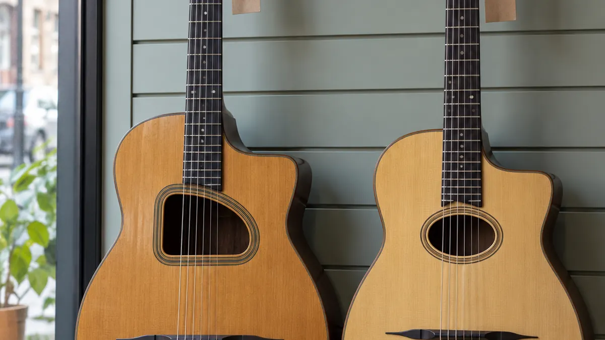 Deux guitares manouche côte à côte, l'une à grande ouïe en D, l'autre à petite ouïe ovale, cordiers dorés au premier plan